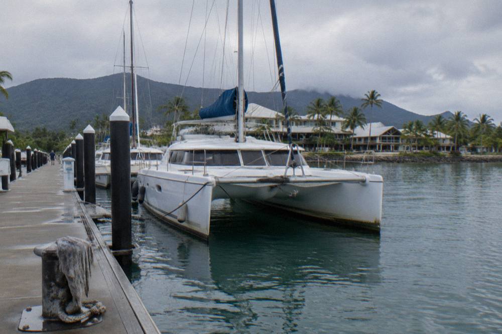 Cruise catamarans moored at a Cairns marina wharf with the terminal building behind them