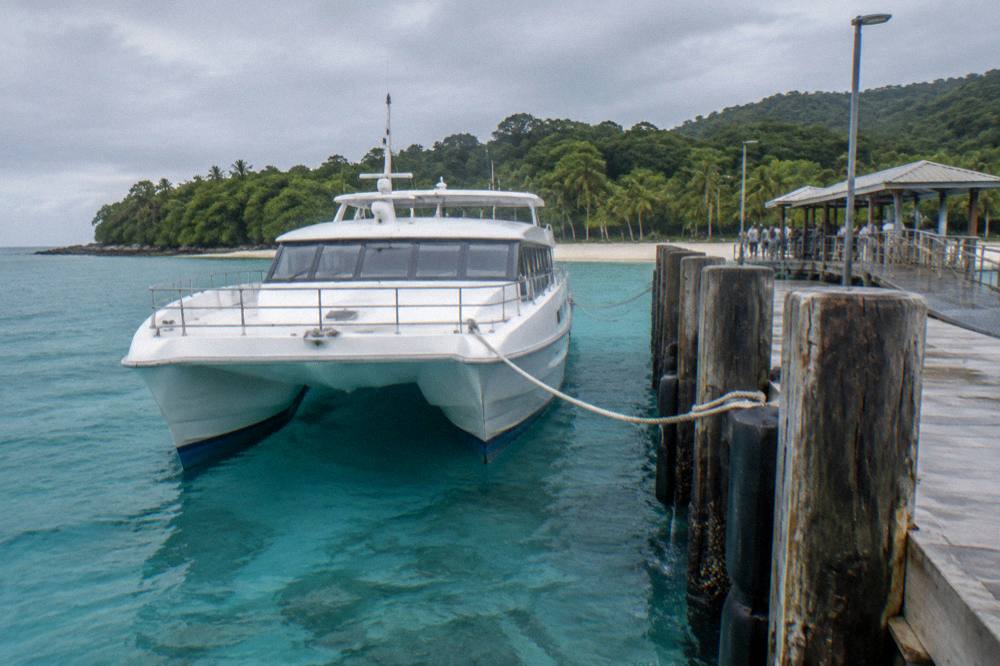 A fast catamaran moored at a tropical island jetty