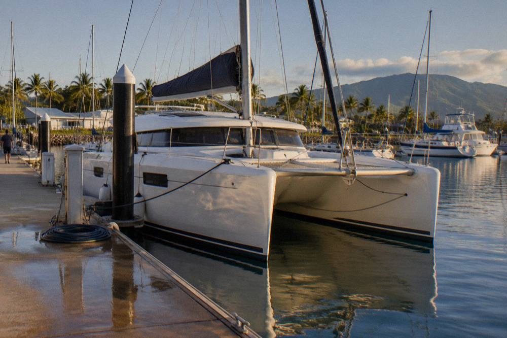 A fast catamaran moored at a Cairns marina in early morning light