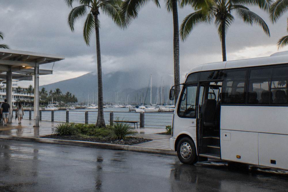 A shuttle coach parked outside a tropical Queensland hotel entrance