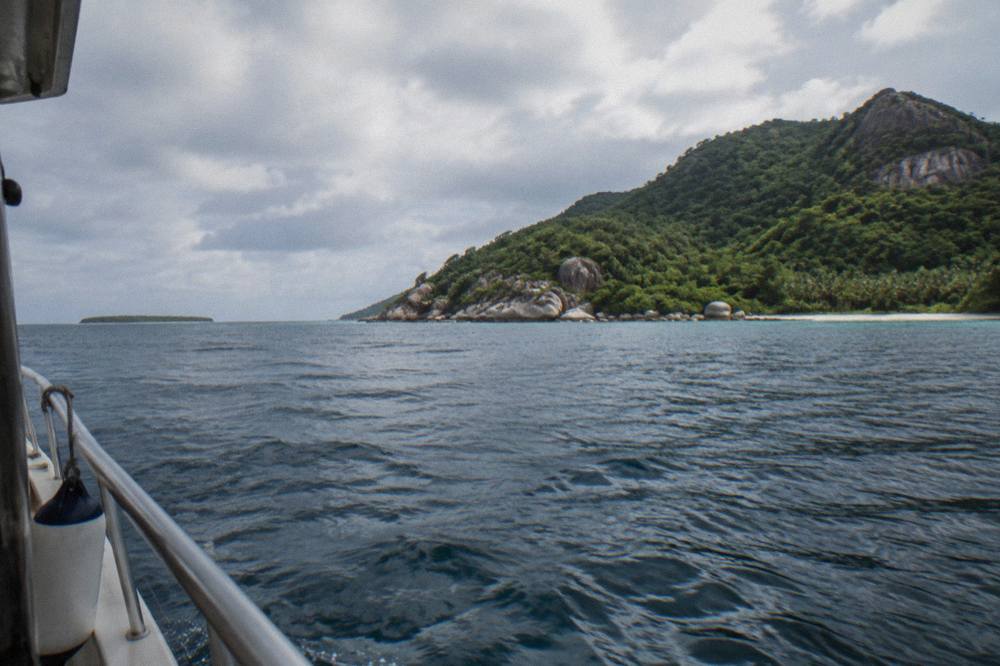 Two tropical islands seen from the water across a calm coral sea