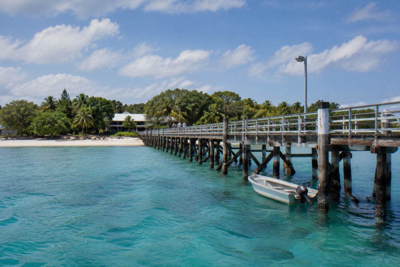 Green Island jetty and calm turquoise water under scattered tropical clouds