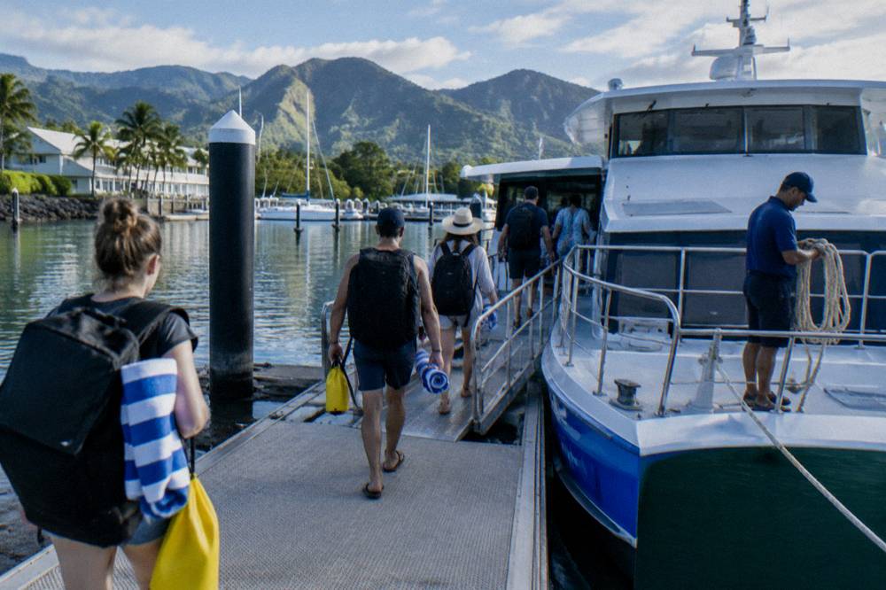 Passengers boarding a fast catamaran at a Cairns marina berth in early morning